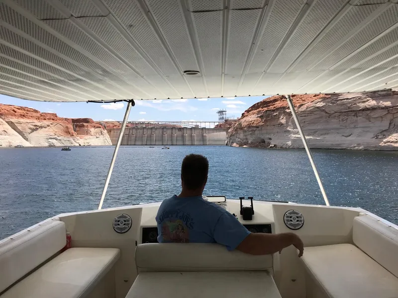 Slide: The Image of Man steering 1996 Stardust Cruiser houseboat near a dam in September 2022. - 4