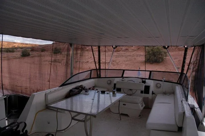 Slide: The Image of Interior of 1996 Stardust Cruisers boat with seating and table, desert background. - 5