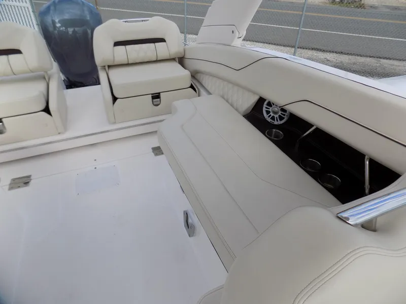 Slide: The Image of 2021 Regal LX6 boat interior with beige seating and cup holders. - 15