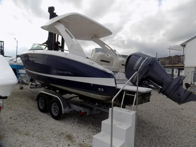 Slide: The Image of 2021 Regal LX6 boat on trailer with Yamaha outboard motor, parked on gravel. - 3