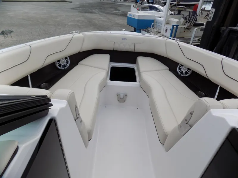 Slide: The Image of 2021 Regal LX6 boat interior with white cushioned seating and storage compartment. - 5