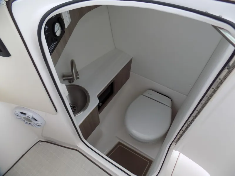 Slide: The Image of 2021 Regal LX6 boat bathroom with compact toilet and sink. - 6