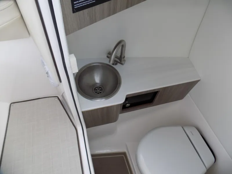 Slide: The Image of 2021 Regal LX6 boat bathroom with sink and toilet, featuring modern design and compact layout. - 7