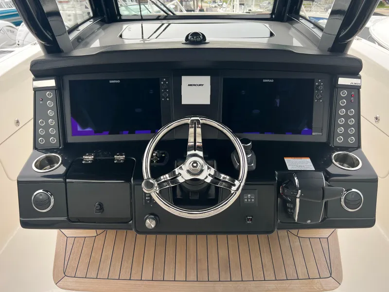 Slide: The Image of 2024 Robalo R360 boat dashboard with dual screens and steering wheel. - 11