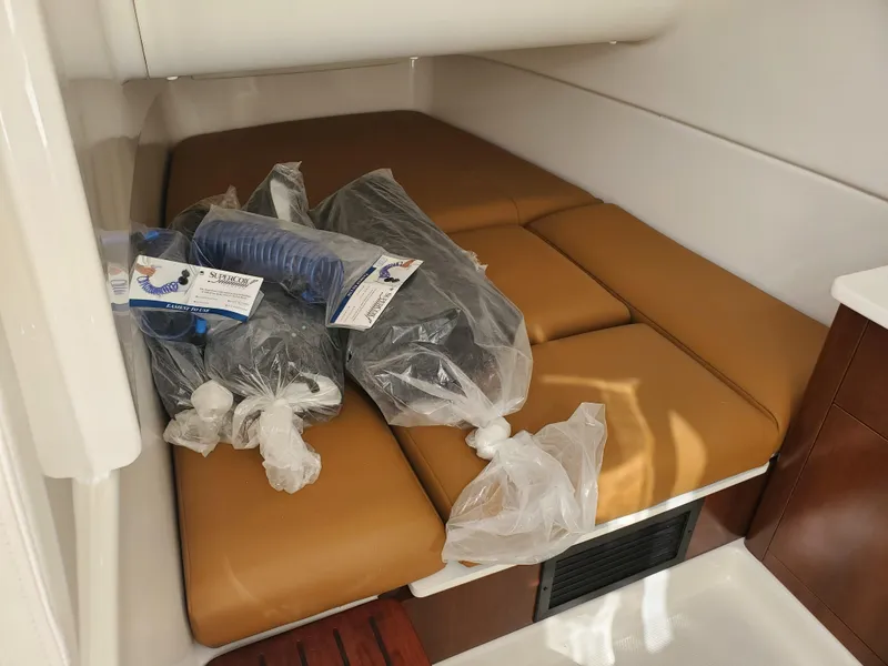 Slide: The Image of 2024 Robalo R360 cabin with tan cushions and packaged accessories. - 18