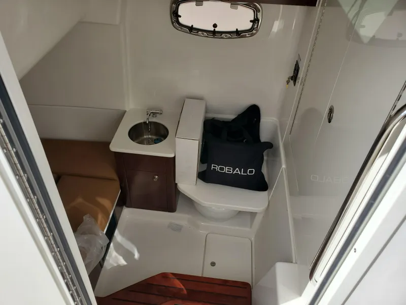 Slide: The Image of 2024 Robalo R360 boat interior with sink, toilet, and seating area. - 19