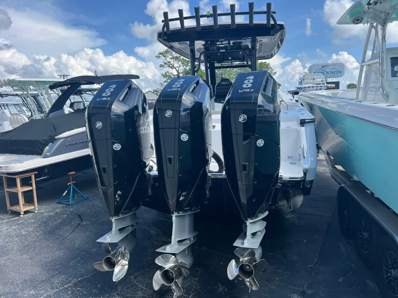 Slide: The Image of 2024 Robalo R360 boat with triple outboard engines, docked under a clear sky. - 6