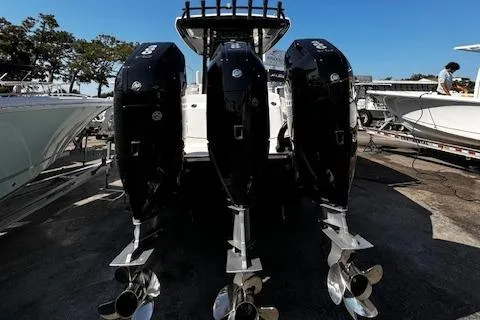 Slide: The Image of 2024 Robalo R360 boat with triple outboard engines, docked at a marina. - 7