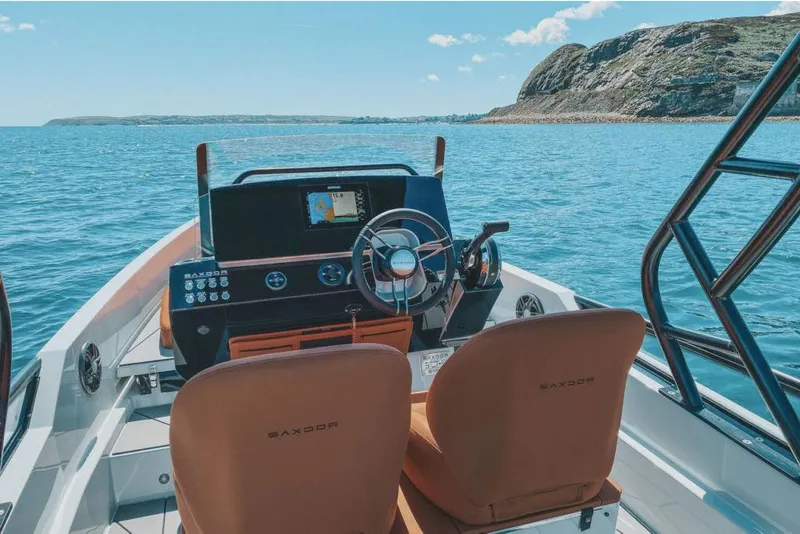 Slide: The Image of 2023 Saxdor 200 SPORT boat interior with dual seats and navigation system on open water. - 4