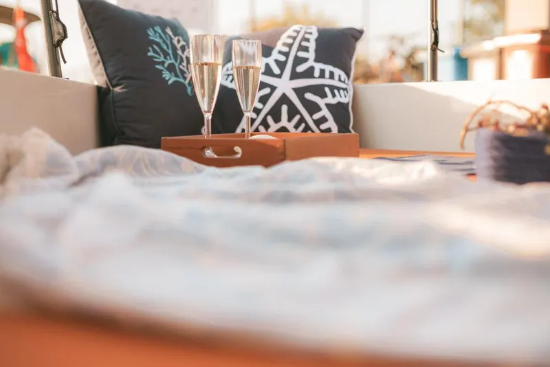 Slide: The Image of Cozy seating area on a 2023 Saxdor 200 SPORT boat with pillows and champagne glasses. - 8