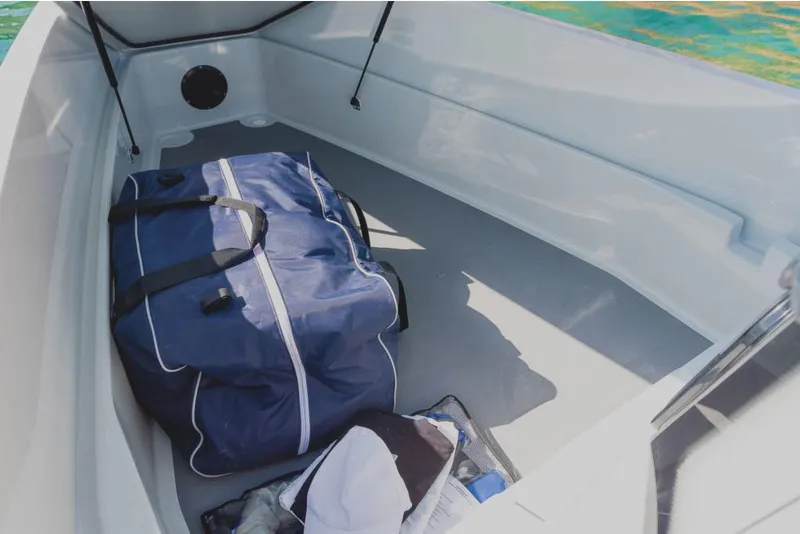 Slide: The Image of Spacious storage area in the 2023 Saxdor 200 Pro Sport boat with a blue duffel bag. - 2