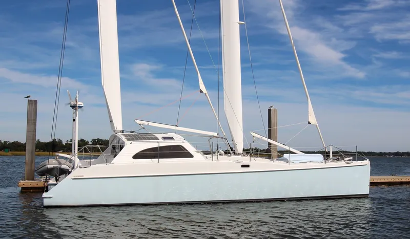 The Image of Sleek 2016 Chris White ATLANTIC 47 catamaran docked on calm water under blue sky. - 0