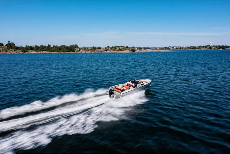 Slide: The Image of Saxdor 320 GTR 2023 speeding on a clear blue lake with distant shoreline. - 8