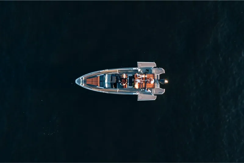 Slide: The Image of Aerial view of 2023 Saxdor 320 GTR boat cruising on dark water. - 9