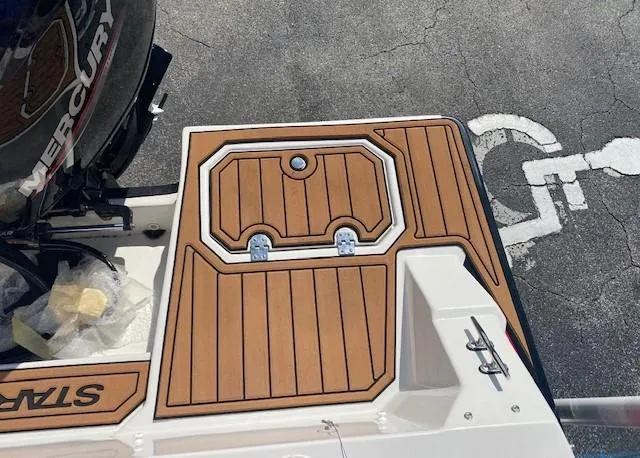 Slide: The Image of 2022 Starcraft SVX 191 OB boat deck with teak-style flooring and Mercury outboard motor. - 30