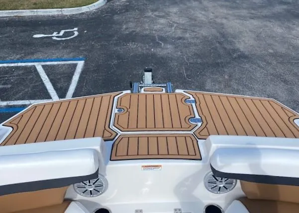 Slide: The Image of 2022 Starcraft SVX 191 OB boat stern with teak flooring in a parking lot. - 7