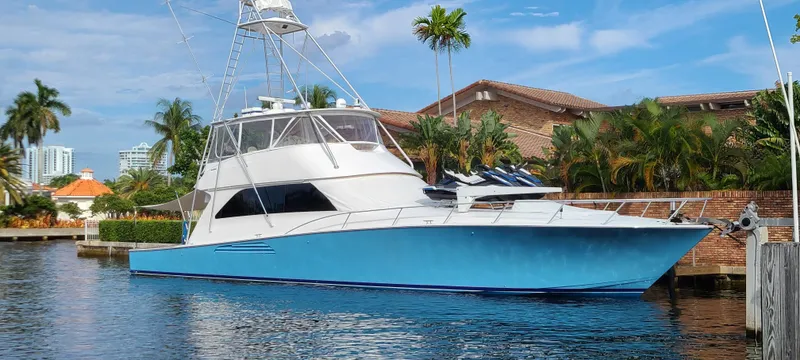 The Image of 2006 Viking 74 Convertible yacht docked by tropical waterfront homes. - 0