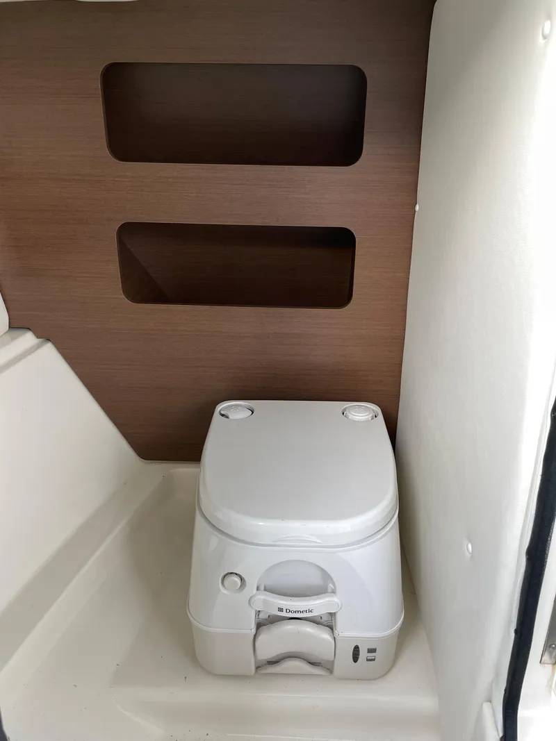 Slide: The Image of 2015 Sea Ray 240 Sundeck boat interior with portable toilet. - 12