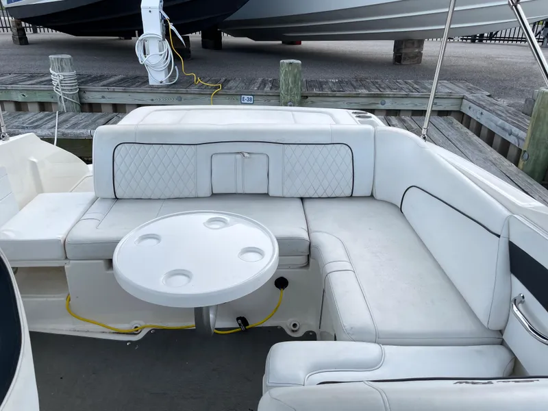 Slide: The Image of 2015 Sea Ray 240 Sundeck interior with white seating and round table. - 4