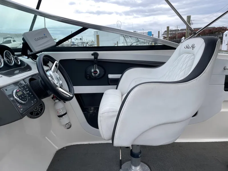 Slide: The Image of 2015 Sea Ray 240 Sundeck helm with Garmin navigation system and white captain's chair. - 5