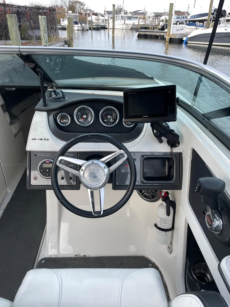 Slide: The Image of 2015 Sea Ray 240 Sundeck boat dashboard with steering wheel and navigation equipment. - 7