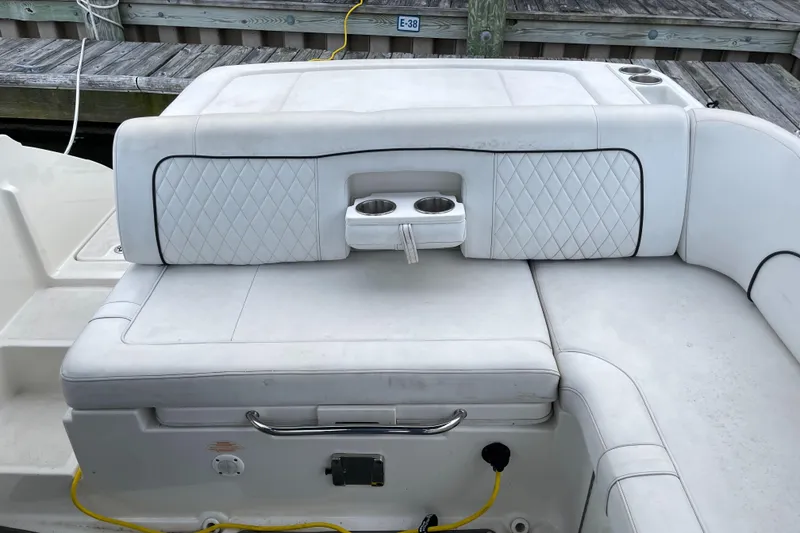 Slide: The Image of 2015 Sea Ray 240 Sundeck boat with white cushioned seating and cup holders. - 9
