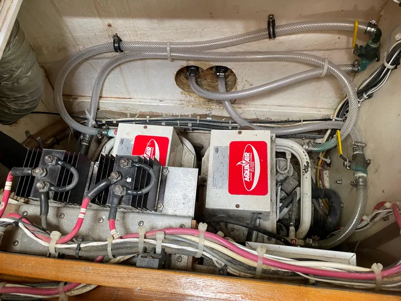 Slide: The Image of Engine compartment of a 1974 Custom Center Cockpit boat, featuring mechanical components and wiring. - 17