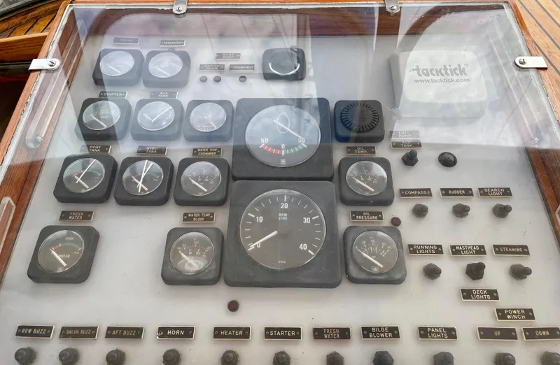 Slide: The Image of 1974 Custom Center Cockpit control panel with various gauges and switches under glass. - 6