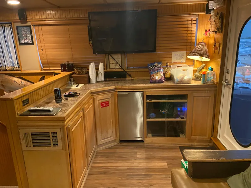 Slide: The Image of Cozy 1995 Custom Mothership interior with wooden cabinets, TV, and snacks on the counter. - 10