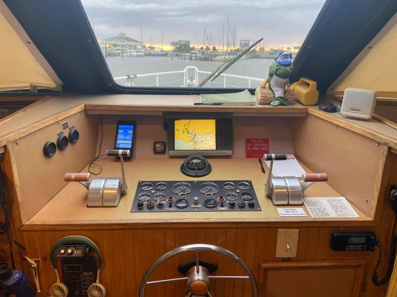 Slide: The Image of Boat cockpit with navigation controls, steering wheel, and view of marina at sunset. Custom Mothership 1995. - 8