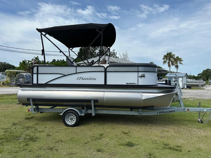 Slide: The Image of 2022 Manitou 18 Aurora pontoon boat on trailer with black canopy. - 3
