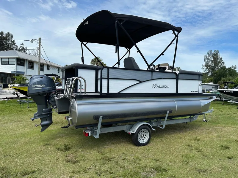 Slide: The Image of 2022 Manitou 18 Aurora pontoon boat with Yamaha outboard motor on trailer. - 4