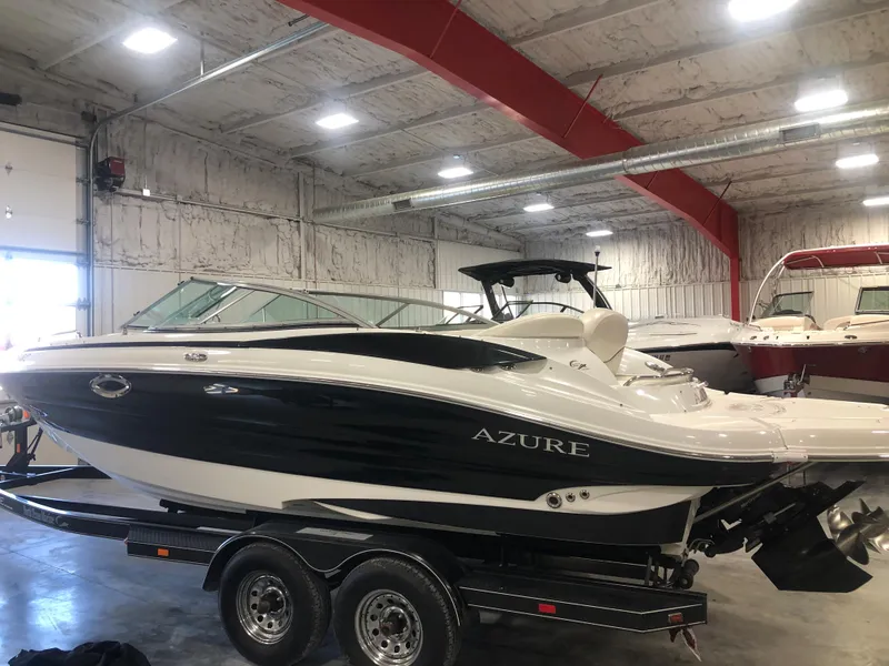 Slide: The Image of 2010 Azure 258 boat in a warehouse, on a trailer, with a sleek black and white design. - 3