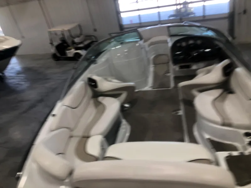 Slide: The Image of Interior of a 2010 Azure 258 boat with beige seating in a garage. - 5