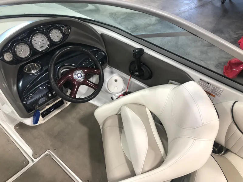 Slide: The Image of Interior of a 2010 Azure 258 boat with steering wheel and white seating. - 9