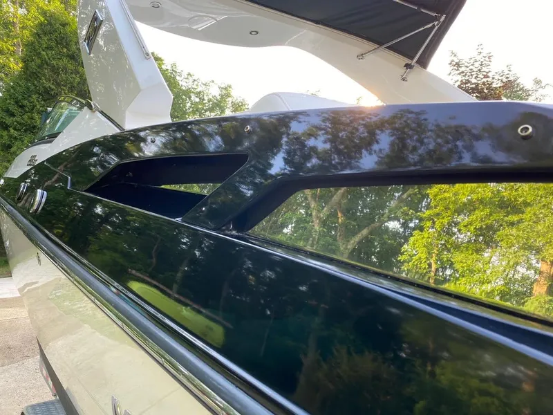 Slide: The Image of 2015 Monterey 288 Super Sport boat, sleek black exterior, reflecting lush greenery. - 11