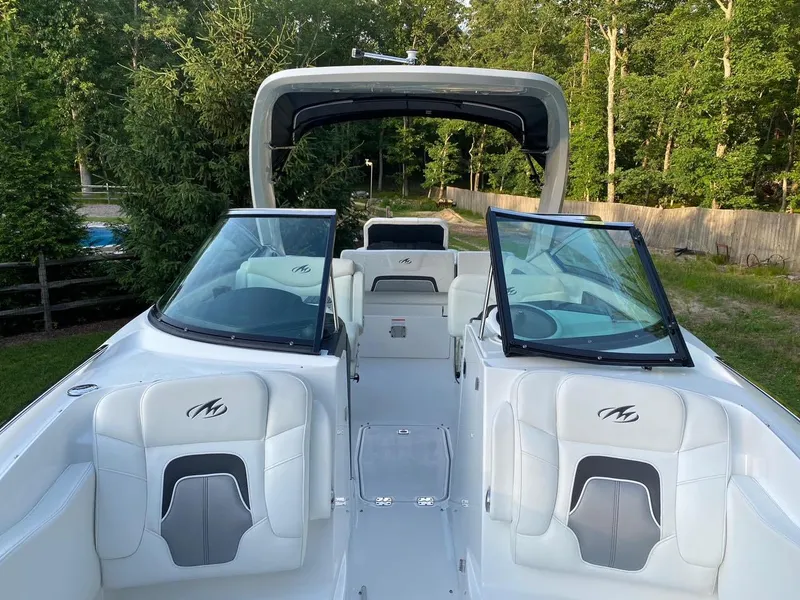 Slide: The Image of 2015 Monterey 288 Super Sport boat with open seating, surrounded by lush greenery. - 6