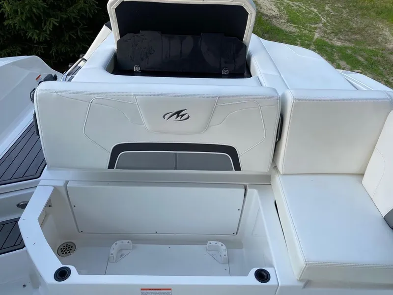 Slide: The Image of 2015 Monterey 288 Super Sport boat with open storage compartment and white seating. - 7