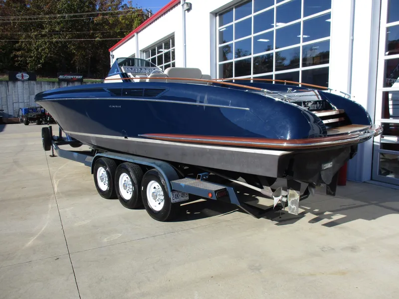 Slide: The Image of 2005 Riva 33 SUNRIVA boat on a triple-axle trailer outside a garage. - 10