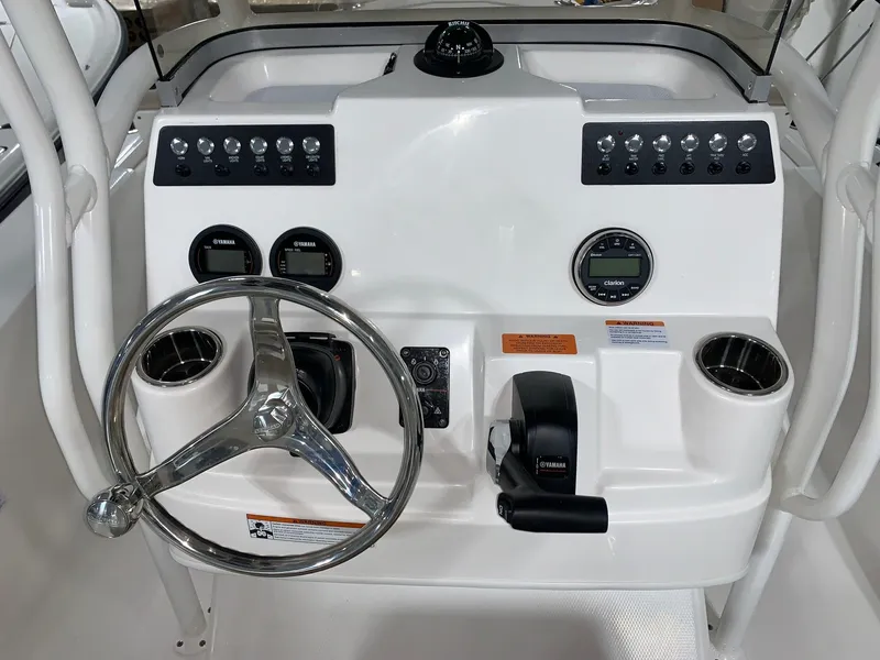 Slide: The Image of Control console of a 2024 Robalo 206 Cayman boat with steering wheel and gauges. - 10