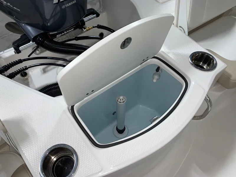 Slide: The Image of 2024 Robalo 206 Cayman boat livewell with open lid and Yamaha engine in background. - 12