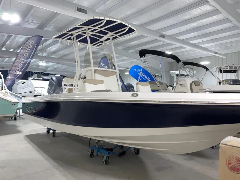 Slide: The Image of 2024 Robalo 206 Cayman boat displayed in a showroom. - 1