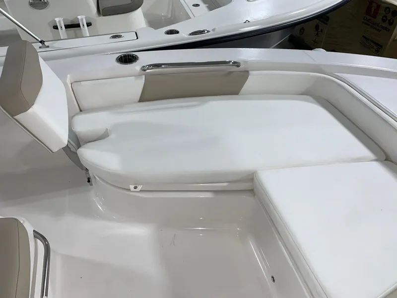Slide: The Image of 2024 Robalo 206 Cayman boat interior seating area with white and beige cushions. - 4