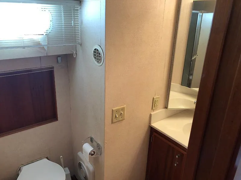Slide: The Image of Bathroom interior of 1989 Pluckebaum 75 Coastal Cruiser with toilet, sink, and window. - 17