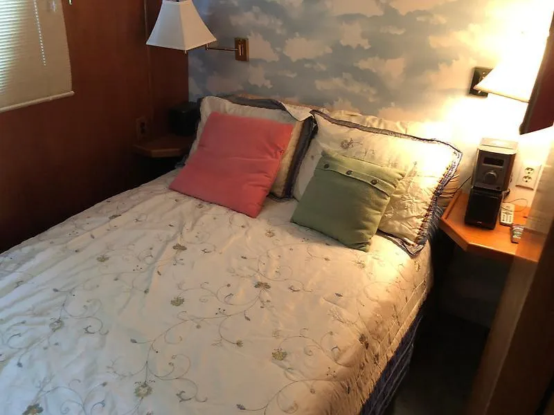 Slide: The Image of Cozy bedroom in 1989 Pluckebaum 75 Coastal Cruiser with cloud-themed wallpaper. - 25