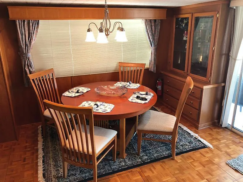 Slide: The Image of Dining area in 1989 Pluckebaum 75 Coastal Cruiser with wooden table and chairs. - 26