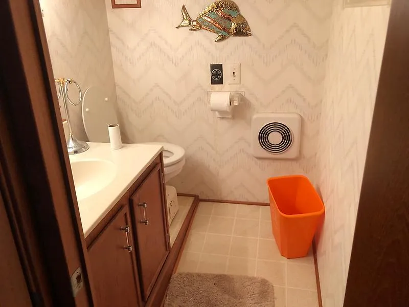Slide: The Image of Bathroom on a 1989 Pluckebaum 75 Coastal Cruiser with fish decor and orange trash bin. - 27