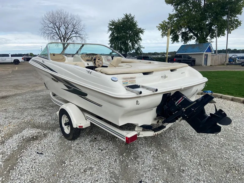 Slide: The Image of 2000 Sea Ray 180BR boat on trailer, parked on gravel lot near lake. - 7