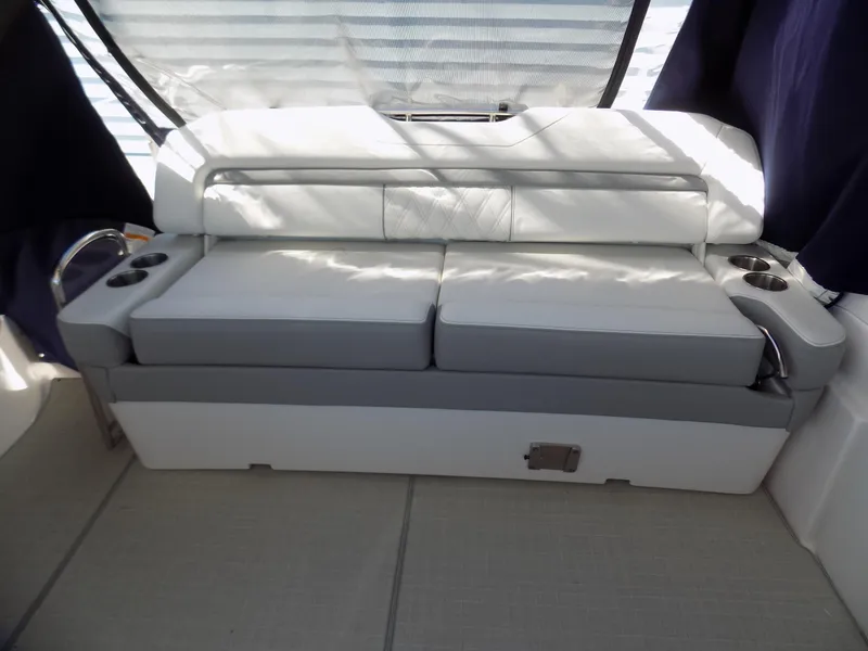 Slide: The Image of 2022 Regal 33 XO boat interior with cushioned seating and cup holders. - 12