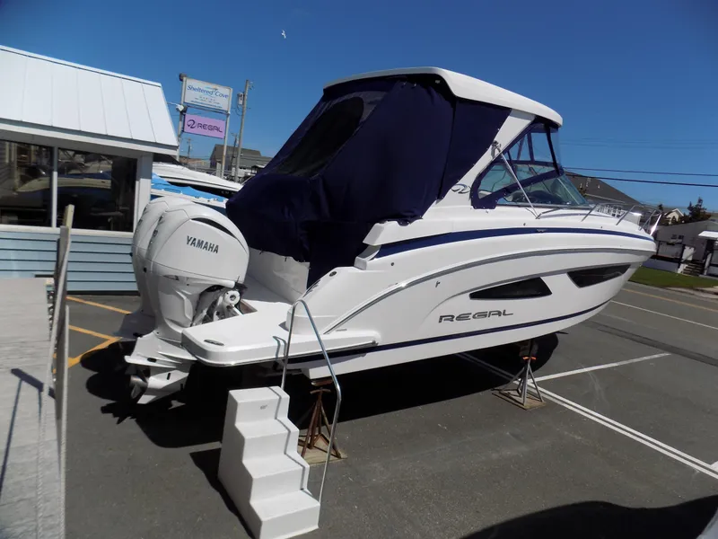 Slide: The Image of 2022 Regal 33 XO boat with Yamaha engine, displayed on a stand outdoors. - 3
